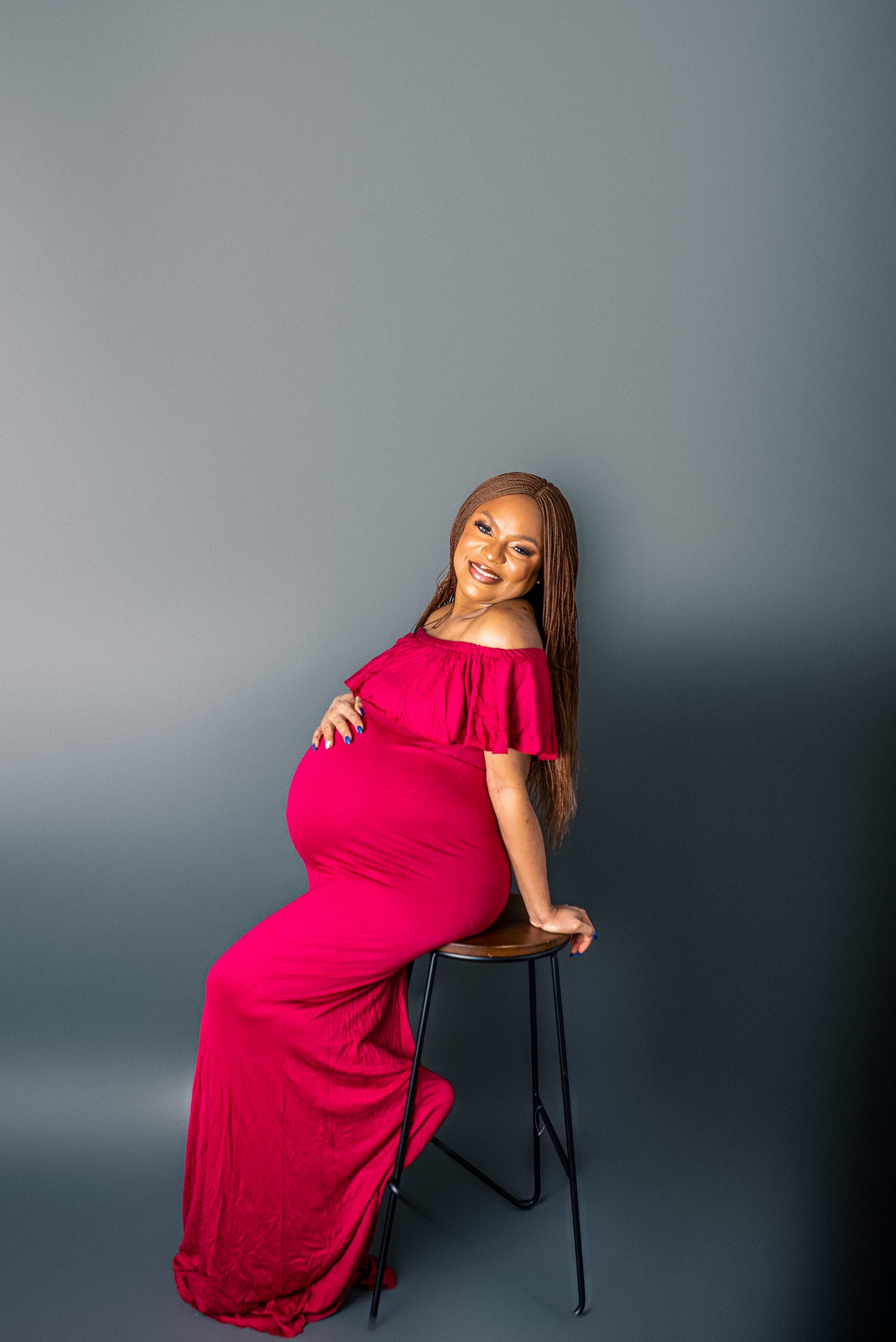 Studio photo of a glowing mother-to-be embracing her legacy.